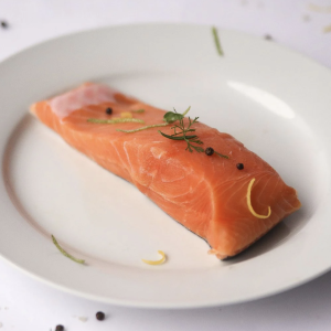 King Salmon Portion on White Plate garnished with herbs on top