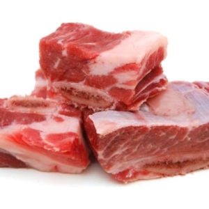 Three chunks of our beautiful short ribs stacked on top of each other on a white background