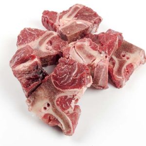 Raw Organic Beef Ox Tail stacked on white background